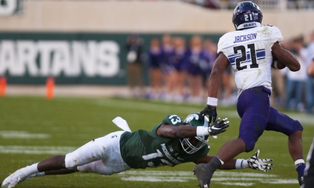 <p>Sophomore defensive back Vayante Copeland (13) attempts to tackle Northwestern running back Justin Jackson (21) during the game against Northwestern on Oct. 15, 2016 at Spartan Stadium. The Spartans were defeated by the Wildcats, 54-40.</p>