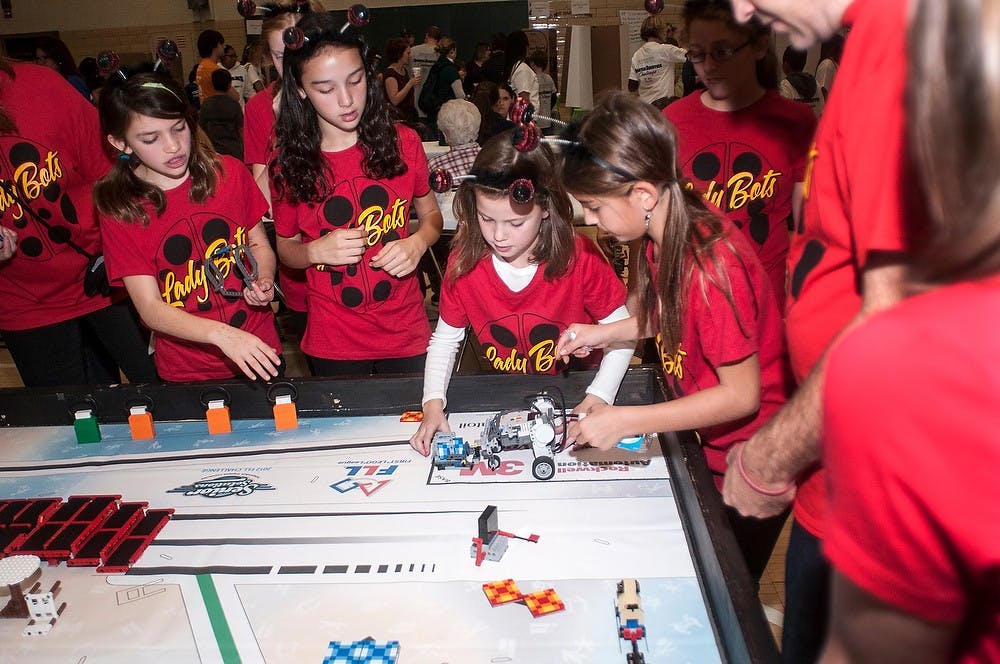 	<p>From left to right, fifth graders from Herbison Woods School in Dewitt, Amalia Scorsone and Maria Vostrizansky watch as Grace Sheaffer works on their lego robot at the 7th annual Spartan Engineering <span class="caps">FIRST</span> <span class="caps">LEGO</span> League Challenge East Lansing Regional Tournament on Nov. 10, 2012 at IM Circle. Katie Stiefel/ State News</p>