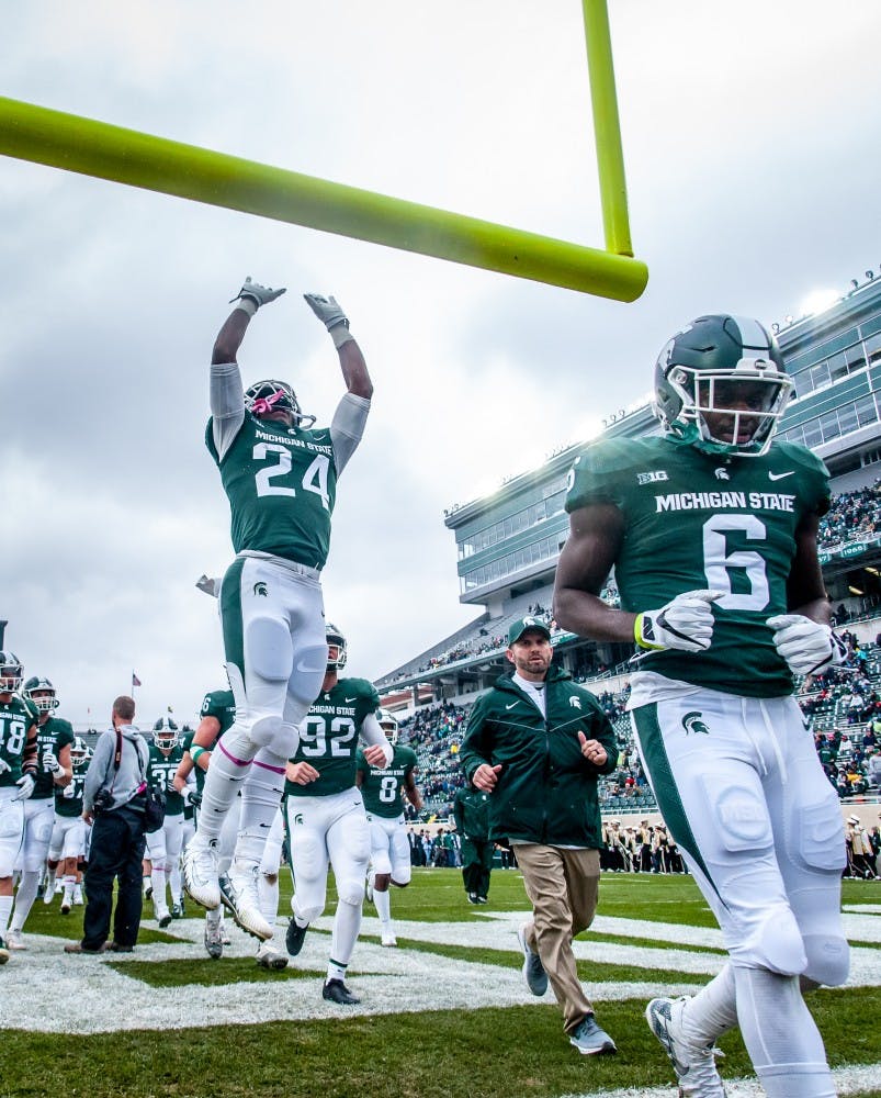 Freshman running back Elijah Collins (24) jumps to touch the cross bar prior to the game against Purdue on Oct. 27, 2018 at Spartan Stadium.