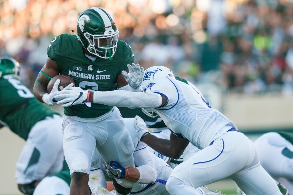 Sophomore running back LJ Scott (3) is tackled by Furman safety Trey Robinson (2) during the home football game against Furman on Sept. 2, 2016 at Spartan Stadium. LJ Scott rushed for a total of 108 yards and scored one touchdown. 