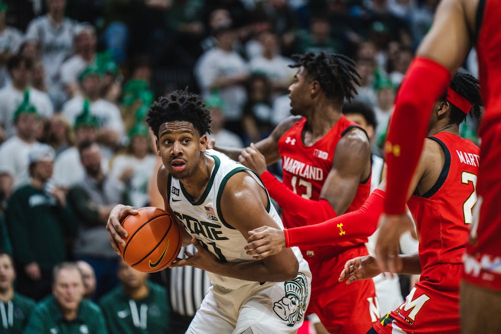 <p>Junior guard A.J. Hoggard (11) looks for an open teammate while Maryland players swarm around him on Feb. 7, 2023. The Spartans defeated the Terps with a score of 63-58.</p>