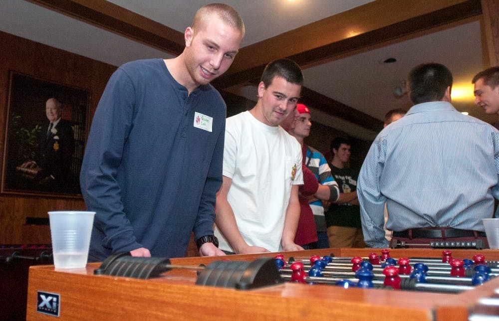 Business finance freshman Quinn Miller plays foosball with accounting junior Kevin Muth at Delta Chi fraternity on Tuesday, Sept. 18. Delta Chi is one of 27 fraternities particpating in Rush Week. Griffin Zotter/The State News