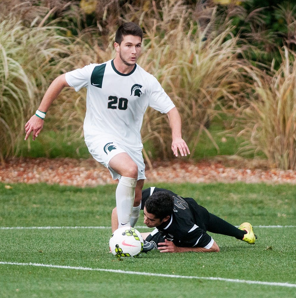 <p>Junior midfielder Jason Stacy steals the ball from Western defender Sean Hazen on Oct. 15, 2014, at DeMartin Soccer Stadium at Old College Field. The Spartans defeated the Broncos, 4-0. Aerika Williams/The State News</p>