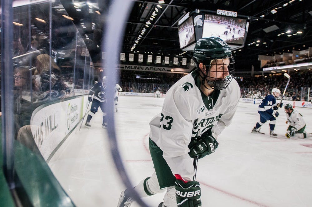 Junior forward Cody Milan (23) makes his way down the ice during the game on Feb. 16, 2018 at Munn Ice Arena. The Spartans beat the Nittany Lions 4-2. 