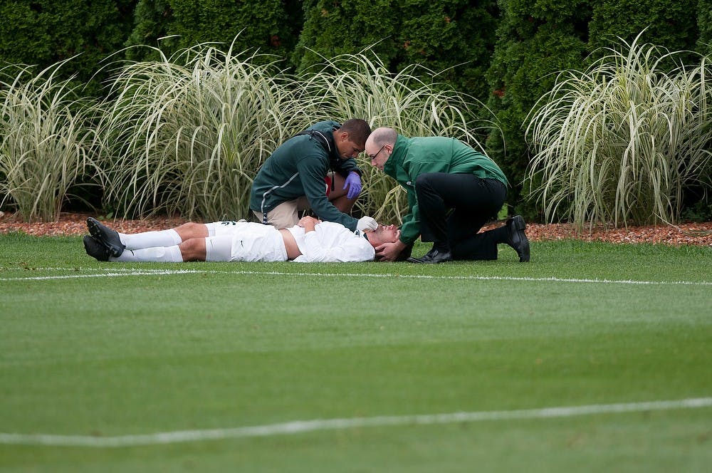 <p>Senior forward Adam Montague receives help after getting injured during the game against Valparaiso on Sept. 11, 2014, at DeMartin Stadium at Old College Field. The Crusaders defeated the Spartans 1-0 in regulation time.  Aerika Williams/The State News</p>