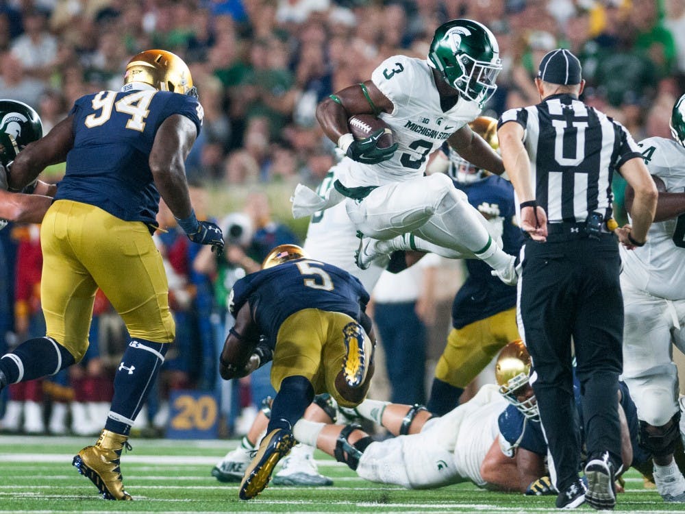 Sophomore running back LJ Scott (3) leaps over Notre Dame linebacker Nyles Morgan (5) during the game against Notre Dame on Sept. 17, 2016 at Notre Dame Stadium in South Bend, Ind. The Spartans defeated the Fighting Irish, 36-28.
