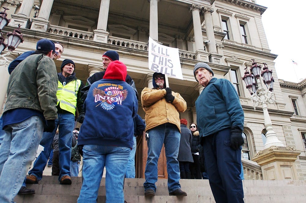 	<p>From right, Okemos resident John Ware and Mayville, Mich., resident Robert Fisher stand on the steps in support of unions Thursday, Dec. 6, 2012, at the Lansing Capitol building. The unrest was sparked by Governor Rick Snyder and the Republican-controlled state L=egislature&#8217;s move to introduce right-to-work legislation for Michigan. Katie Stiefel/ State News</p>