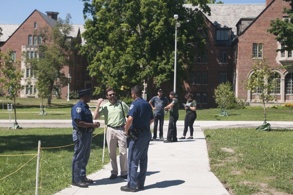 Sparty's service manager Michael Harding, second from left, talks to MSU Police officers Dave Isabell, left, and N. Spyke, right on August 1, 2016 on Abbot Road. They were discussing evacuations due to a gas leak nearby.