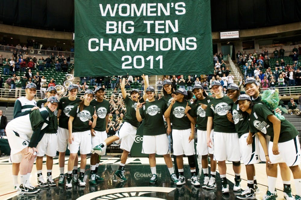 The women's basketball team poses as senior guard Brittney Thomas, center, jokes around after raising the Big Ten championship banner on Thursday at Breslin Center. It is the third time in program history the women have clenched at least a share of the title. Lauren Wood/The State News