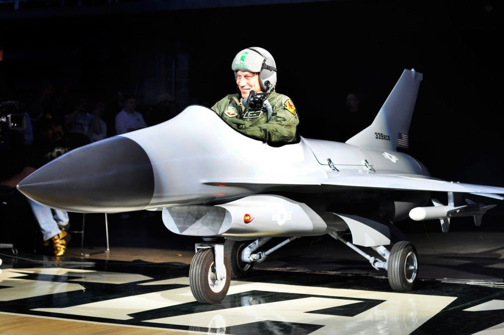 <p>Men’s basketball head coach Tom Izzo dives to the floor of Breslin Center in a fighter jet model on Oct. 14, 2011, at Midnight Madness.</p>