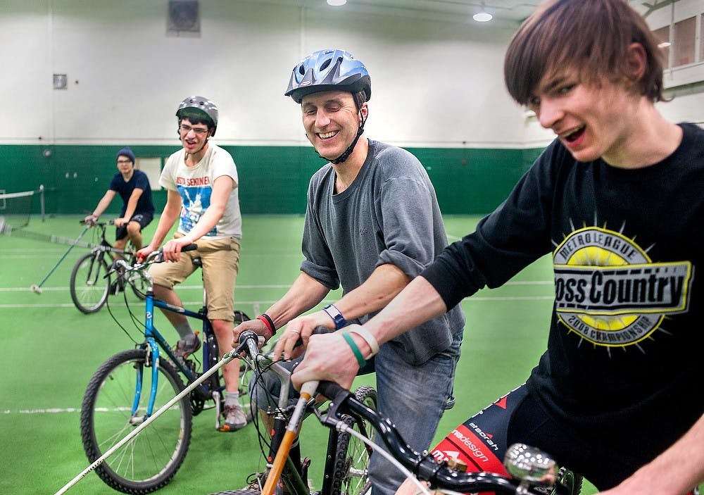 MSU bike polo player Tim Potter, center, laughs with fishery and wildlife junior Dan Ryan during a bike polo game, Friday, March 1, 2013, at IM Sports-West. Justin Wan/The State News