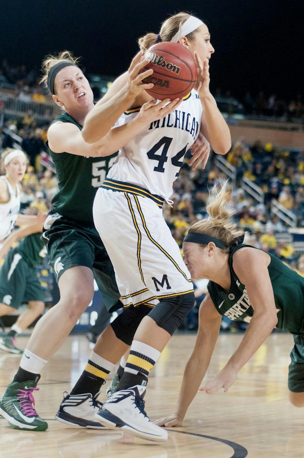 	<p>Sophomore forward Becca Mills tries to steal the ball from Michigan center/forward Rachel Sheffer as senior forward Courtney Schiffauer falls to the ground Feb. 16, 2013, during a game against Michigan at Crisler Center in Ann Arbor. The Spartans lost 69-70. Julia Nagy/The State News</p>