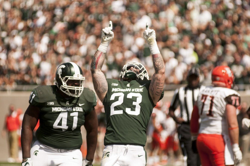 Senior linebacker Chris Frey (23) and junior defensive tackle Gerald Owens (41) celebrate a first down during the game against Bowling Green on Sep. 2, 2017, at Spartan Stadium. The Spartans defeated the Falcons, 35-10.