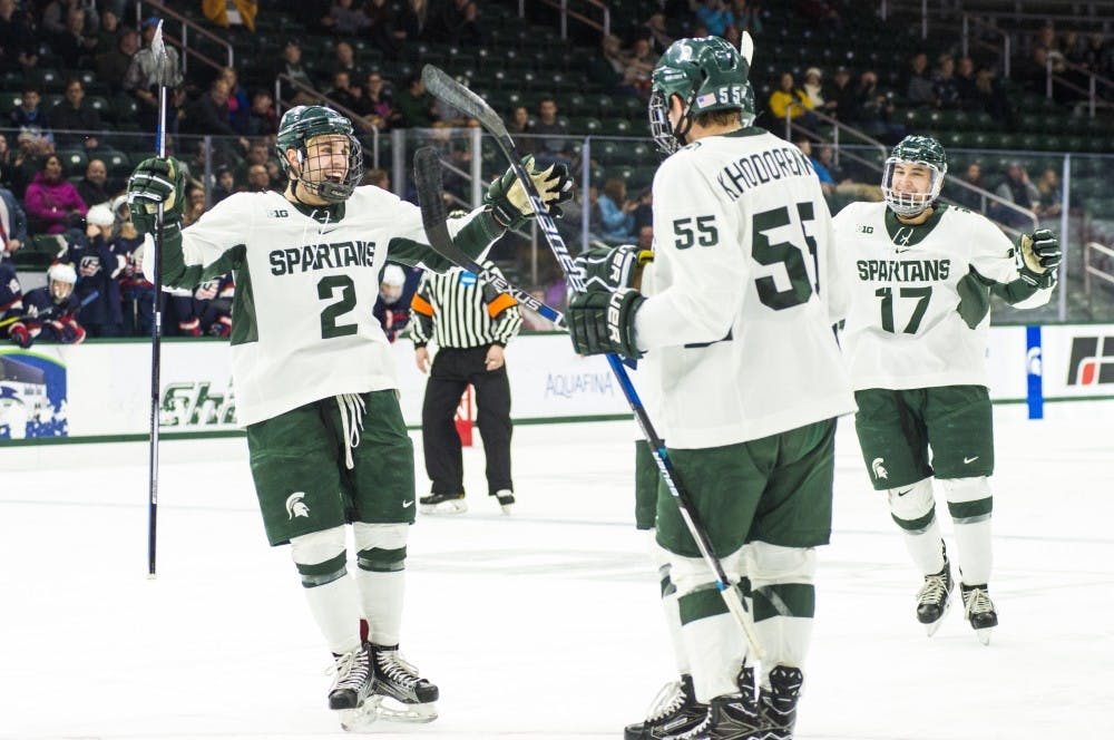 Sophomore defenseman Zach Osburn (2) celebrates with his teammates after the second goal of the game by freshman defenseman Damian Chrcek (7) during the first period in the exhibition game against U.S. National Team Development Program U-18 Program on Dec. 4, 2016 at Munn Ice Arena. The Spartans led the first period, 2-1.