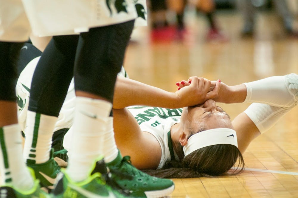 Junior forward Aerial Powers closes her eyes in agony on Dec, 3, 2015 during the second half of the game against Louisville at Breslin Center. Powers was going for a layup when she landed on her left leg badly. The Spartans were defeated by the Cardinals, 78-85. 