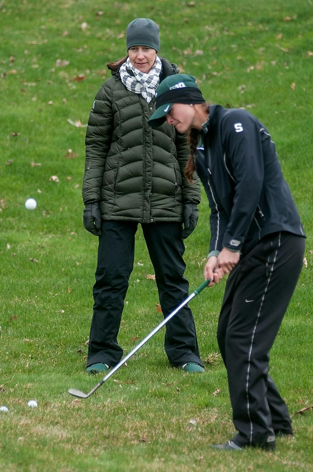 <p>Women's golf head coach Stacy Slobodnik coaches senior Lindsey McPherson while she practices her chip shots April 21, 2015, at Forest Akers West Golf Course.  The women's golf team will be headed to Indianapolis for the Big 10 Championship Friday, April 24th. Allyson Telgenhof/The State News.</p>