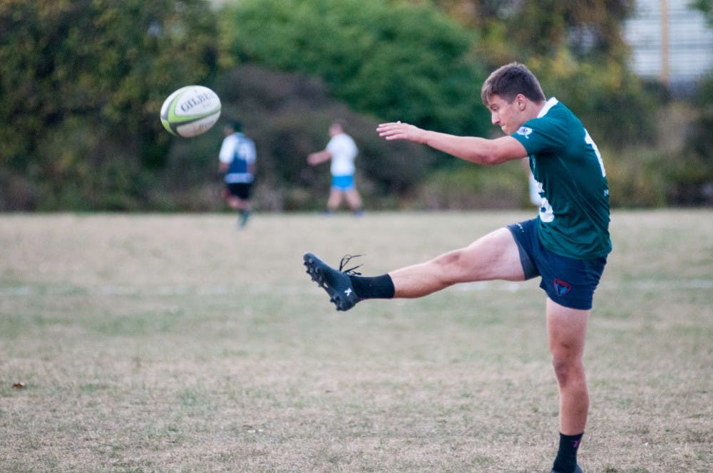 Sophomore business preference major Sean Wakefield kicks a ball at practice on Oct. 5, at the Service Road field. The rugby club practiced through some light rain on the day.