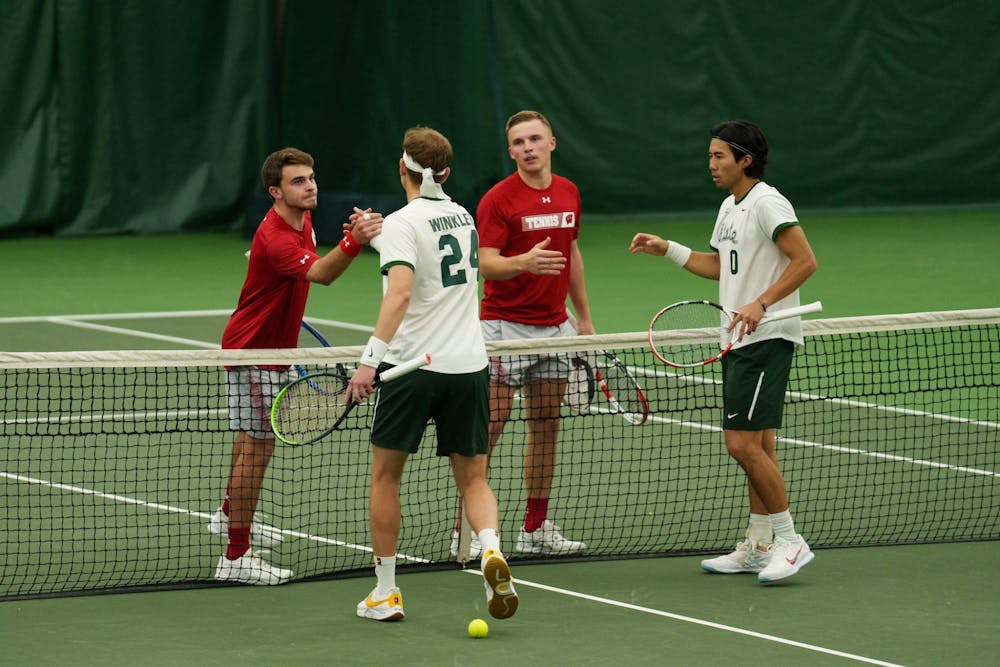 <p>Michigan State junior Matsuno Kazuki and redshirt senior Jack Winkler give Wisconsin respect after their doubles match, on March 25, 2022. Spartans lose 5-2 against Wisconsin.</p>