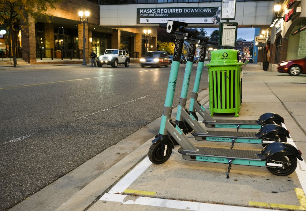 3 Gotcha scooters sitting off Albert Ave in downtown East Lansing in their designated zone on October 26, 2020.