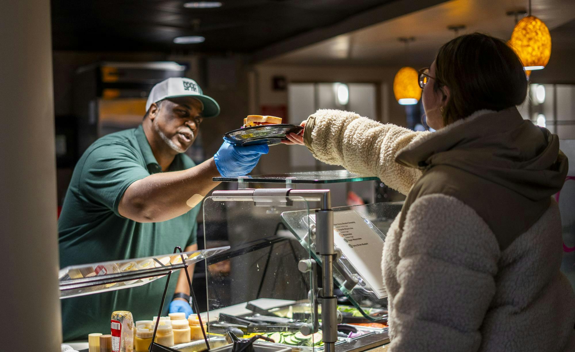 An MSU culinary services employee serves a sandwich to a customer in the Gallery dining hall on Feb. 8, 2025. The Gallery has had many recent upgrades, including the new ice cream station and a build-your-own sandwich bar. 