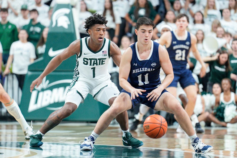 <p>Hillsdale’s sophomore guard Cole McWhinnie (11) dribbles the ball as Michigan State’s freshman guard Jeremy Fears Jr. (1) guards him during a game between them at the Breslin Center on Oct. 25, 2023. The Spartans defeated the Chargers 85-43.</p>
