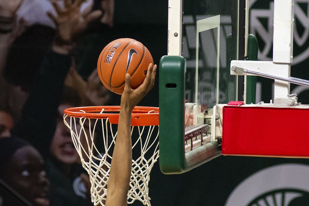 <p>Junior forward Marcus Bingham Jr. (30) shoots at the basket in attempt to score. Michigan State triumphed over Notre Dame, 80-70, on Nov. 28, 2020. </p>