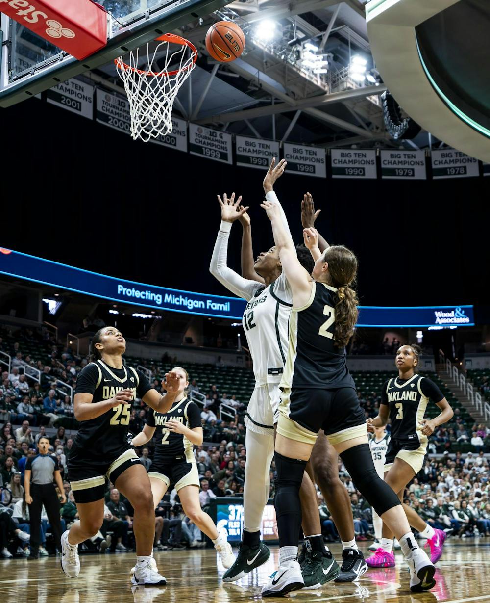 <p>Michigan State redshirt senior Isaline Alexander (12) throws the ball to make a basket while Oakland University freshman guard Makenzie Luehring (2) tries to block her at the Breslin Student Events Center in East Lansing, Mich., on Nov. 23, 2025.&nbsp;</p>