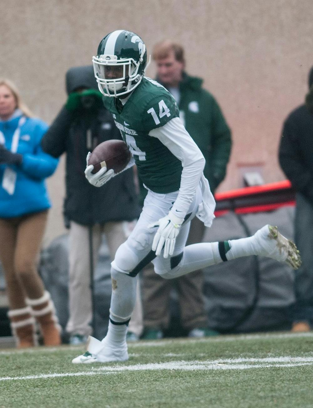 <p>Senior wide receiver Tony Lippett runs the ball into the end zone Nov. 22, 2014, during the game against Rutgers at the Spartan Stadium. The Spartans defeated the Scarlet Knights, 45-3. Aerika Williams/The State News </p>