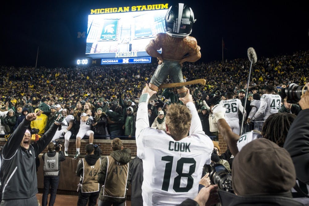 <p>Senior quarterback Connor Cook presents the Paul Bunyan trophy to  Spartan fans on Oct. 17, 2015, after the game against Michigan at  Michigan Stadium in Ann Arbor. The Spartans defeated the Wolverines,  27-23.</p>