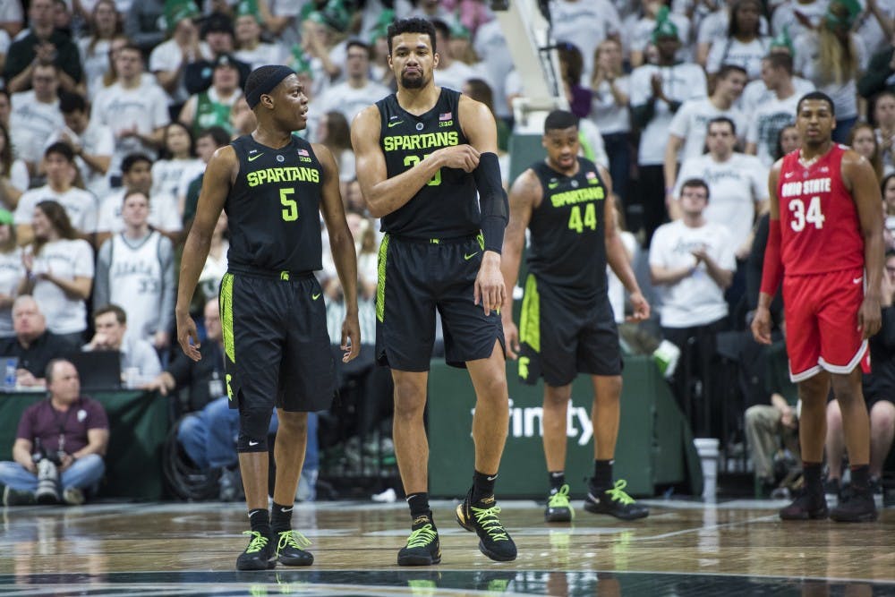 Junior guard Cassius Winston (5) and senior forward Kenny Goins (25) talk during the men's basketball game against Ohio State at Breslin Center on Feb. 17, 2019. Nic Antaya/The State News