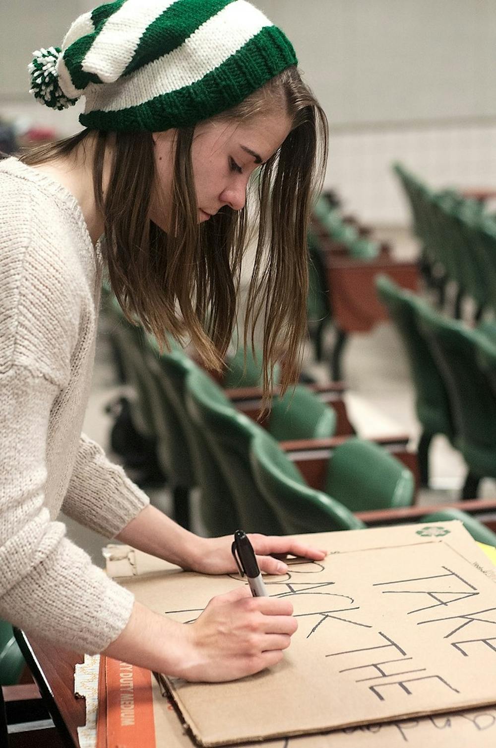 <p>James Madison freshman Casey Paskus makes a sign for Take Back the Night April 7, 2015, in B115 Wells Hall. Paskus made 16 signs with anti-sexual assault messages on them for a march to the state capital that will take place April 8. Allyson Telgenhof/The State News.</p>
