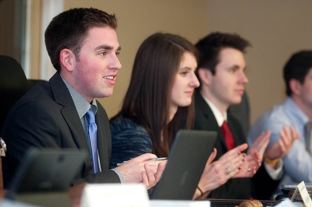 	<p>Current <span class="caps">ASMSU</span> president and international relations junior Evan Martinak applauds for a new inductee during the officer election meeting, April 24, 2013, in Student Services. Martinak was re-elected as president for a second term during the meeting. Danyelle Morrow/The State News</p>