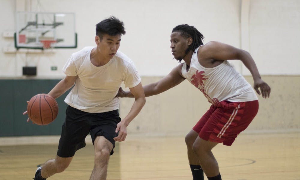 <p>Sophomore hospitality business major Kuncheng Lin drives towards senior communications major Robert Whitley on Sep. 12, at IM Sports West. The two took a lot of outside shots in their one on one game.</p>