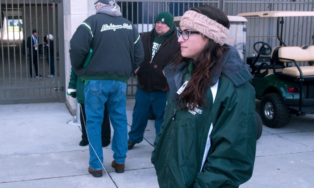 Green coat criminal justice junior Isabel Berkson stands guarding the player entrance before the game against Penn State on Nov. 28, 2015 at Spartan Stadium. 