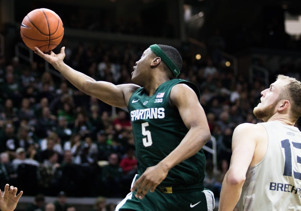 Junior guard Cassius Winston (5) reaches for the ball during the game against Oakland University at Breslin Center on Dec. 21, 2018. The Spartans defeated the Grizzlies, 99-69.