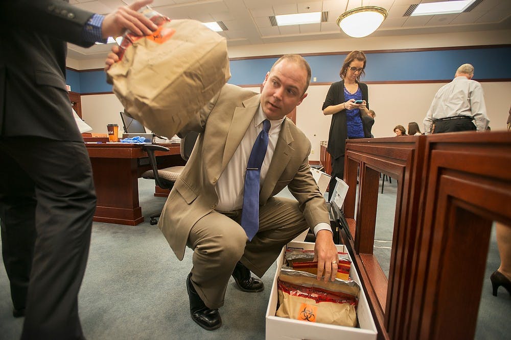	<p>Sgt. Andrew McCready prepares evidence before the Connor McCowan trial Oct. 10, 2013, at the Ingham County Circuit Court in Lansing. McCowan is on trial for open murder after the Feb. 23 killing of <span class="caps">MSU</span> student Andrew Singler. Julia Nagy/The State News</p>