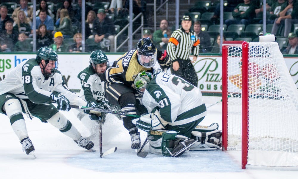 <p>Sophomore goalie John Lethemon (31) is run into during the game against Western Michigan on Oct. 20, 2017, at Munn Ice Arena. Lethemon was slow to get up after the play. The Spartans defeated the Broncos 6-4.</p>