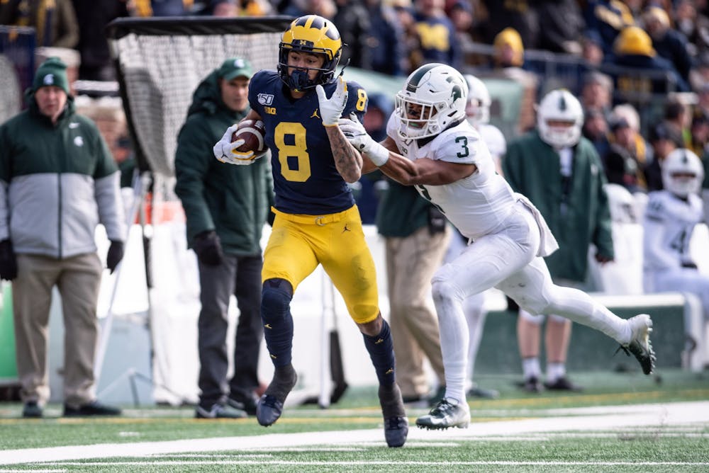 <p>Michigan wide receiver Ronnie Bell (8) is pushed out of bounds by sophomore safety Xavier Henderson (3) during the game Nov. 16, 2019 at Michigan Stadium. The Spartans fell to the Wolverines, 44-10.</p>