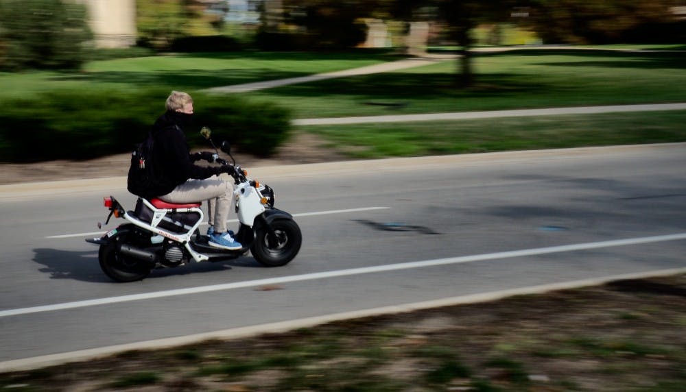 MSU student drives a moped in front of the MSU Library on October 23, 2019. 