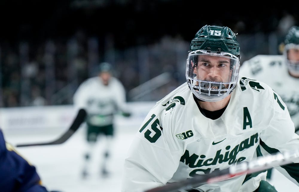 <p>Graduate student defender Christian Krygier (15) watches his opponent during a game against Notre Dame at Munn Ice Arena on Feb. 3, 2023. The Spartans defeated the Fighting Irish 3-0.</p>