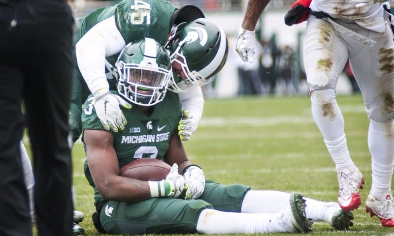 Senior fullback Prescott Line (45) shares a moment with sophomore running back LJ Scott (3) during the first half of the game against Ohio State on Nov. 19, 2016 at Spartan Stadium. The Spartans were defeated by the Buckeyes, 17-16.