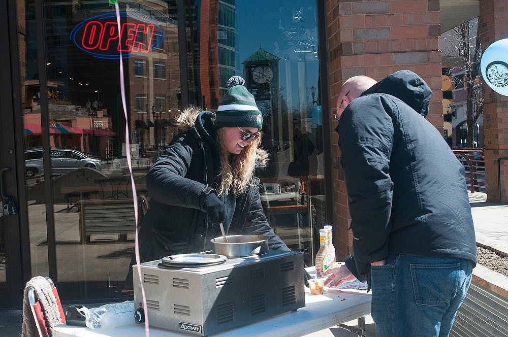 <p>Journalism senior Carly Giles hands out chili March 28, 2015, outside of Leo's Coney Island on Albert Avenue. Eight different restaurants in downtown East Lansing partook in the Chili Cook-Off. Hannah Levy/The State News</p>