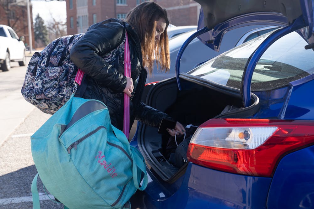 <p>MSU student Madison Crull puts her belongings in her brothers car on Feb. 14, 2023 to leave after a mass shooting that took place on campus on Feb. 13, 2023.</p>