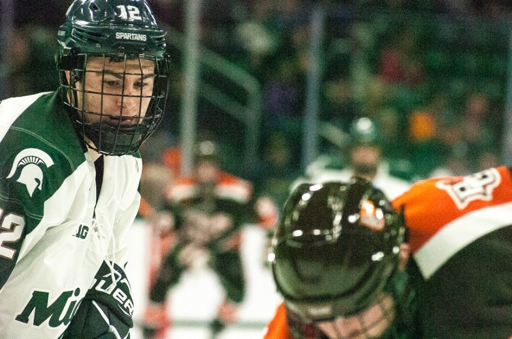 <p>Then-freshman defenseman Tommy Miller (12) watches the puck during the game on Oct. 14, 2017, at Munn Ice Arena. The Spartans defeated the Falcons 3-2 with seconds left in the game.</p>
