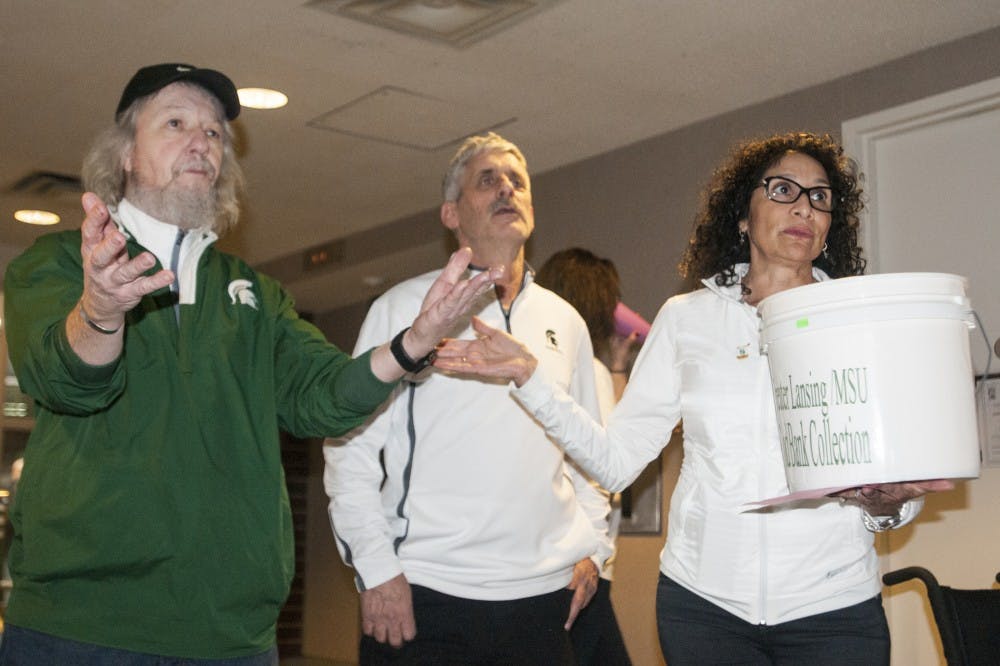 Lupe Izzo gestures to MSU Food Bank advisor Dennis Martell during the MSU Rebounders Club Annual Food Drive on Jan. 29, 2017 at Breslin Center. Lupe Izzo has planned this event in coordination with the MSU Student Food Bank for 23 years and Dennis helped found the food bank. The proceeds and food raised from the fundraiser will be split evenly between the MSU Student Food Bank and Greater Lansing Food Bank. "I've seen how food is really a basic necessity to helping students be successful...I truly believe in inclusion, diversity, and helping out those who come here," Martell said. 