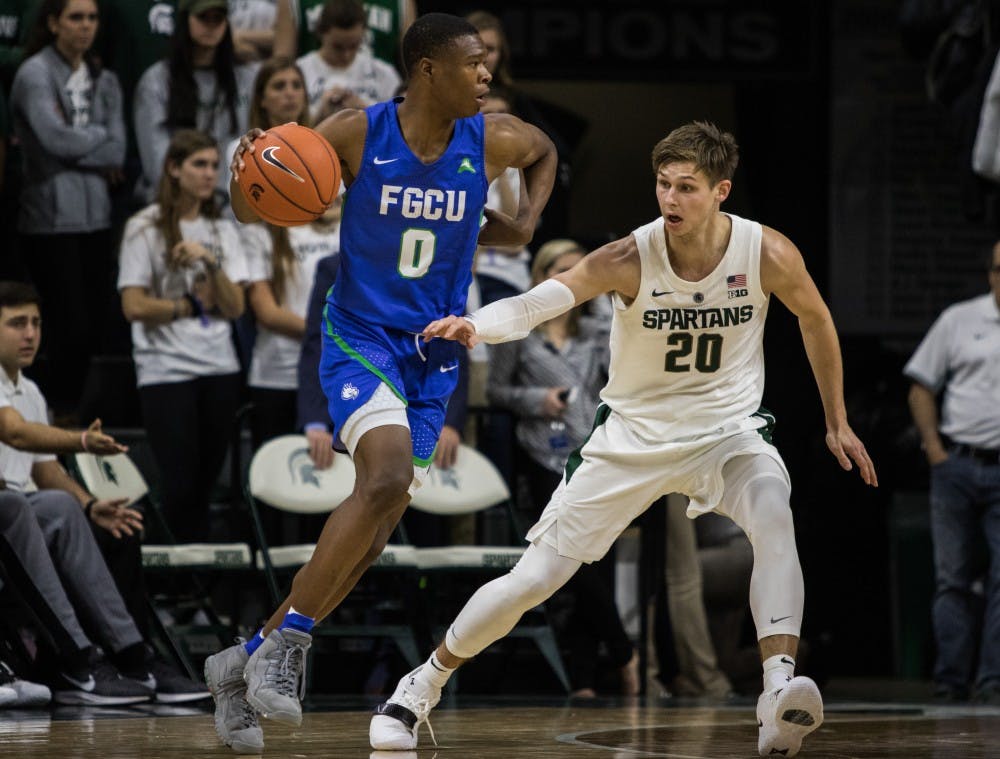 Senior guard Matt McQuaid (20) tries to grab the ball during the game against Florida Gulf Coast University at Breslin Center on Nov. 11, 2018. The Spartans defeated the Eagles, 106-82.