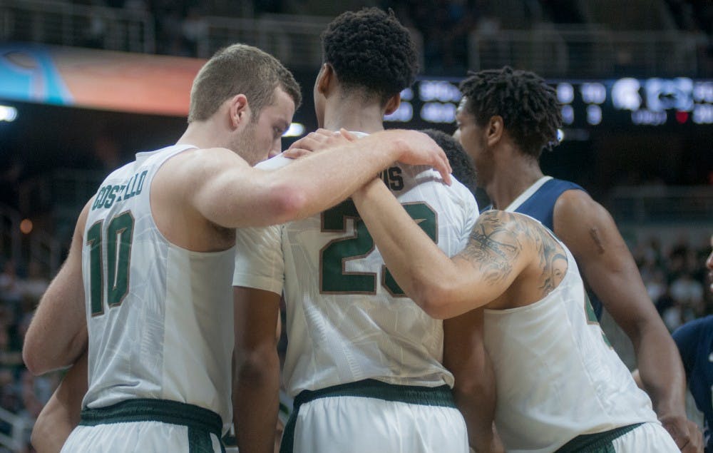 From left to right senior forward Matt Costello, freshman forward Deyonta Davis, and senior guard Denzel Valentine huddle together during the first half of the game on Feb. 28, 2016 at the Breslin Center.  The Spartans defeated the Nittany Lions 88-57. 