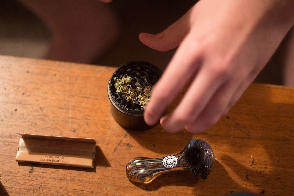 <p>Packaging sophomore Dave grinds marijuana Oct. 3, 2014, at his home in East Lansing. Dave smokes about once every hour. Julia Nagy/The State News</p>