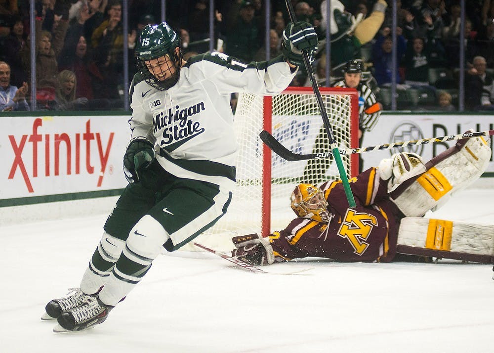 <p>Sophomore forward Mackenzie MacEachern celebrates a goal on Minnesota goaltender Adam Wilcox on Dec. 6, 2014, at Munn Ice Arena. The Spartans tied the Golden Gophers, 3-3, but won the extra point in a shootout. Danyelle Morrow/The State News</p>