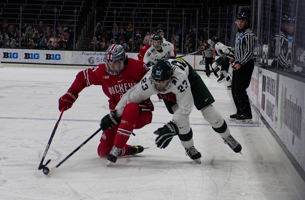 <p>Sophomore left wing Jagger Joshua (23) fights to regain possession of the puck against Ohio State in the first period. The Spartans fell to the Buckeyes, 1-5, at Munn Ice Arena on Jan. 23, 2020.</p>